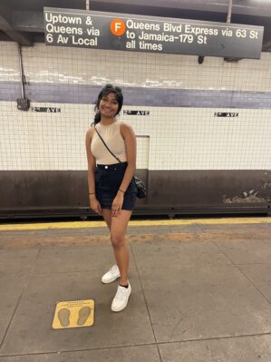 Samidha Sane stands at a subway stop of the New York City Subway.
