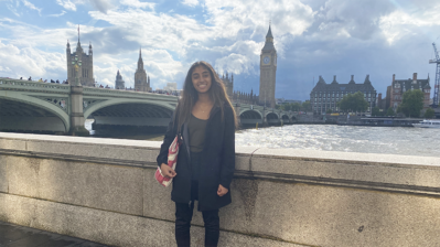 Vasu stands in front of the Thames River in London. On the other side are Parliament and Big Ben. 