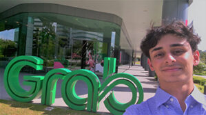 Nick stands in front of the Grab sign outside the headquarters of Grab, a super-app company in Southeast Asia.